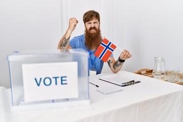 Sticker - Caucasian man with long beard at political campaign election holding norwegian flag annoyed and frustrated shouting with anger, yelling crazy with anger and hand raised