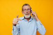 © Tatiana - old man gray beard with glasses talking on the phone isolated background
