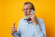© Tatiana - old man talking on the phone emotions yellow background
