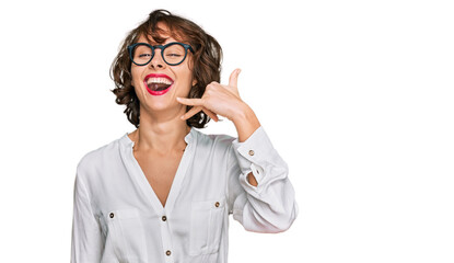 Poster - Young hispanic woman wearing business style and glasses smiling doing phone gesture with hand and fingers like talking on the telephone. communicating concepts.