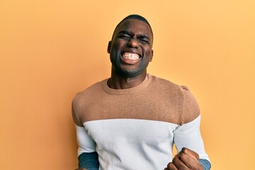 Young african american man wearing casual clothes very happy and excited doing winner gesture with arms raised, smiling and screaming for success. celebration concept.