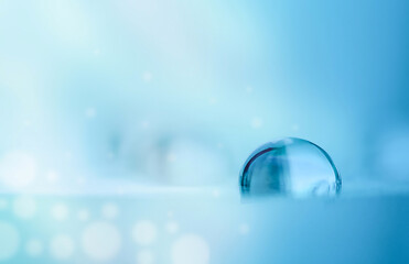 Wall Mural - A drop of water in blue tones in the sun's rays. Macro photography.