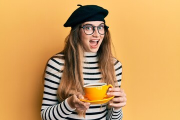 Poster - Young caucasian woman wearing french style drinking a cup of coffee celebrating crazy and amazed for success with open eyes screaming excited.