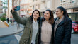 © Krakenimages.com - Mother and daugthers making selfie by the smartphone standing together at street
