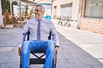 Sticker - Middle age hispanic man wearing business clothes sitting on wheelchair at street