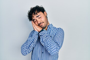 Poster - Young hispanic man wearing casual clothes sleeping tired dreaming and posing with hands together while smiling with closed eyes.