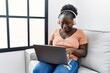 © Krakenimages.com - Young african american woman having video call sitting on sofa at home