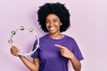 Young African American Woman Playing Tambourine Smiling Happy Pointing With Hand And Finger