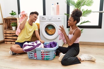 Canvas Print - Man and woman couple playing throwing clothes at laundry room