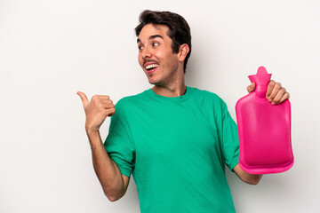 Wall Mural - Young caucasian man holding a water bag isolated on white background points with thumb finger away, laughing and carefree.