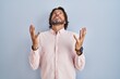 © Krakenimages.com - Handsome middle age man wearing elegant shirt background crazy and mad shouting and yelling with aggressive expression and arms raised. frustration concept.