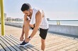 © Krakenimages.com - Hispanic man working out outdoors on a sunny day tying his laces