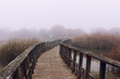 Crossing a bridge of wood in a foggy autumn day 