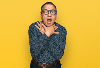 Canvas Print - Middle age indian man wearing casual clothes and glasses shouting and suffocate because painful strangle. health problem. asphyxiate and suicide concept.