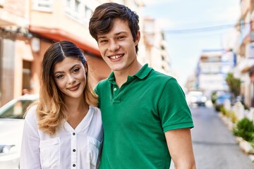 Young caucasian couple smiling happy and hugging standing at the city.