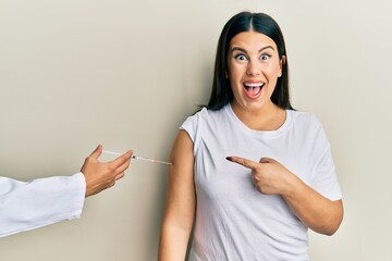 Sticker - Beautiful brunette woman getting vaccine smiling happy pointing with hand and finger