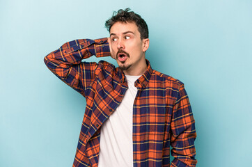 Young caucasian man isolated on blue background being shocked, she has remembered important meeting.