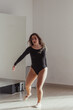 © Esma - A woman standing in a dance pose in a dance studio, dressed in a dance outfit.