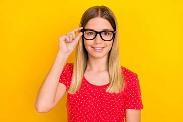 Poster - Photo of young pretty smart girl hand touch eyeglasses ophthalmologist isolated over yellow color background