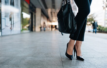 Close Up Shot Of Business Woman's Legs In Black Shoes Standing On City Street. Plenty Of Defocused Empty Space In Background For Text Or Decoration. Shallow Depth Of Field.