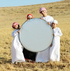 Wall Mural - Arabic family in nature holding copy space banner