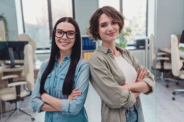 Wall Mural - Photo of two intelligent ceo ladies cross arms stand back to back ready finance innovation project doing in modern workspace