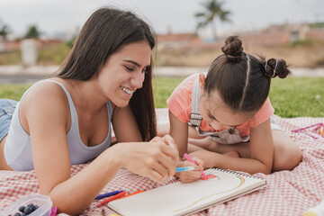 teenage girl enjoy day with little sister at park - girls drawing together outdoor