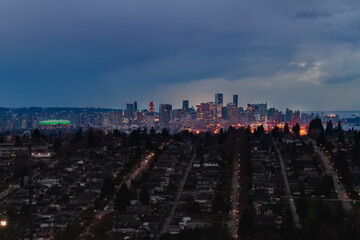 Wall Mural - A scenic view of Downtown vancouver BC shot from a distance at long exposure with telephoto lens clouds vanishing sunlight in background