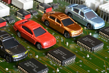 Toy Cars On Electronic Board And Microchip. Conceptual Image For Semiconductor Shortage Disrupting Production Of The Automotive Industry.