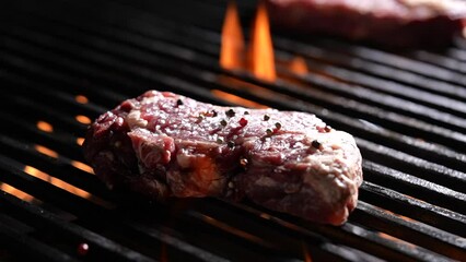 Canvas Print - Raw seansoned steak meat beef dropped on flaming grill. slow motion