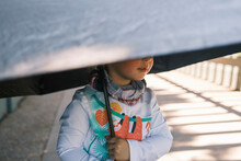 Child Holding An Umbrella For Sun Protection