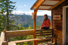 Female Sitting On A Cabin Porch In The Mountains