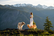 Female In A Dress Posing With Dogs With Mountain Views