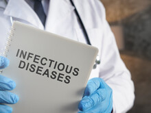 A Doctor Holds Book About Infectious Diseases.