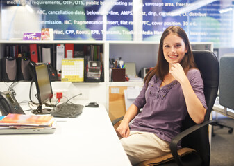 Poster - Feeling positive about the day ahead. Cropped portrait of a young businesswoman sitting at her desk.