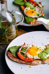 Wall Mural - delicious and appetizing bruschetta with fried eggs and herbs for breakfast