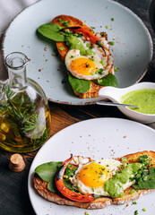 Wall Mural - delicious and appetizing bruschetta with fried eggs and herbs for breakfast