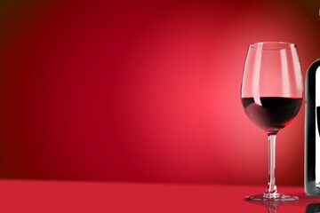 Poster - Red wine in the glass on the desk over red background