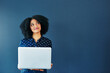 © Camerene Pendl/peopleimages.com - Social media never fails to tickle the mind. Studio shot of an attractive young woman looking thoughtful while using a laptop against a blue background.
