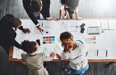 Wall Mural - getting ahead in the business game. high angle shot of a group of businesspeople having a meeting in