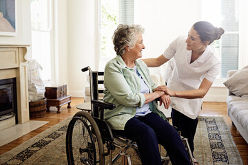 Poster - Helping others is a calling. Shot of a smiling caregiver helping a senior woman in a wheelchair at home.