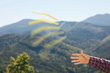 Man throwing boomerang in mountains, closeup view