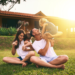 Wall Mural - They have the most fun as a family. Shot of a happy family bonding together outdoors.