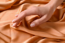 Woman Touching Soft Orange Fabric, Closeup View