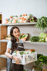 Sticker - Cute girl wearing apron carrying basket of fresh vegetables