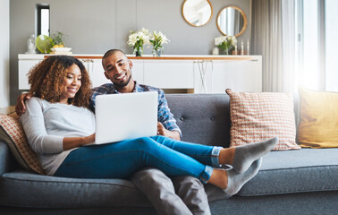 Aufkleber - The comfort of couch surfing. Shot of a young couple relaxing on the sofa at home and using a laptop together.