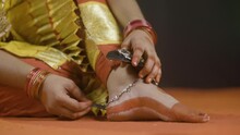 Rack Focus Shot, Bharatnatyam Dancer Removing Music Anklets Or Ghungroo Khatak On Stage After Dancing - Concept Of Classical Dancer, Indian Tradition And Hobbyist