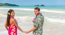 Hawaii Couple In Hawaiian Shirt And Lei Flowers Dress Woman Walking On Beach For Wedding Honeymoon Banner Panoramic. Happy Asian Girl And Man Lovers Holding Hands On Travel Vacation.