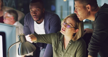 Outlining her ideas to the team. 4k video of a group of businesspeople working late on a computer in an office.
