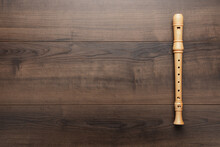 Wooden Recorder On The Wooden Background. Overhead Photo Of Block Flute With Copy Space.